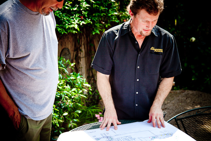 A man standing next to another man in front of a table.